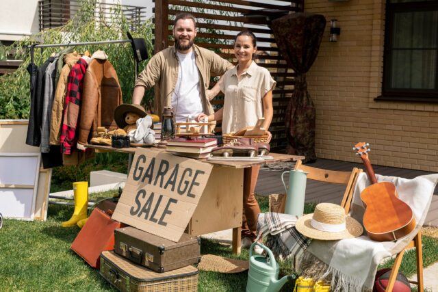 Portrait Of Couple Selling Garage Stuff In Backyard